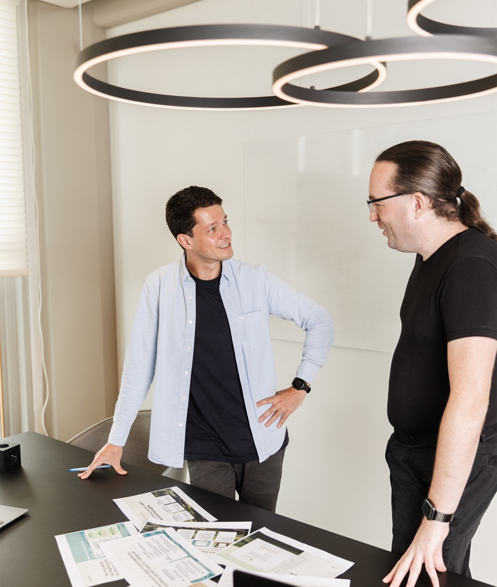 Two members of a small finance team discussing invoices at a desk